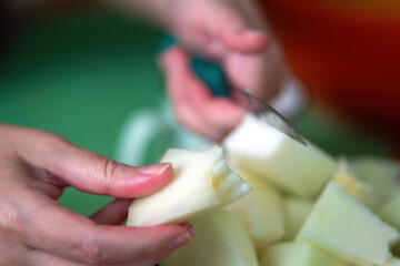 woman hands skillfully slice a ripe melon, showcasing the art of food preparation and the beauty of fresh ingredients, inviting a sensory experience through color and texture