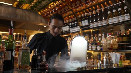 Asian bartender serving mist smoky classical mixing whiskey cocktail fantastic presentation, recommending special welcome tasty creative advertisement drink at beverage counter bar luxury. Vinosity.