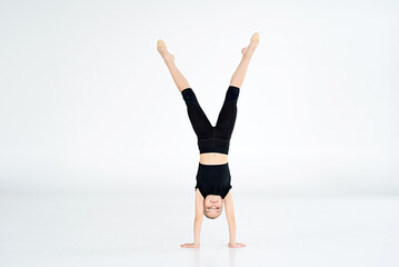 rhythmic gymnast performing with ball, showing skills and stay isolated on white background. Concept of sport, active lifestyle, hobby.