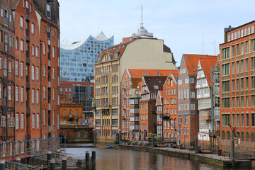 HAMBURG, GERMANY - MAY 31, 2020: View from Holzbrücke on Nikolaifleet canal with historic brick buildings and Elbphilharmonie showing a beautiful contrast between old and new architecture