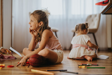 Mother and her daughters engaging in creative activities on the floor at home, fostering bonding and creativity.