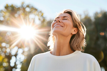 Portrait of happy mature woman enjoying wonderful sunny day in nature