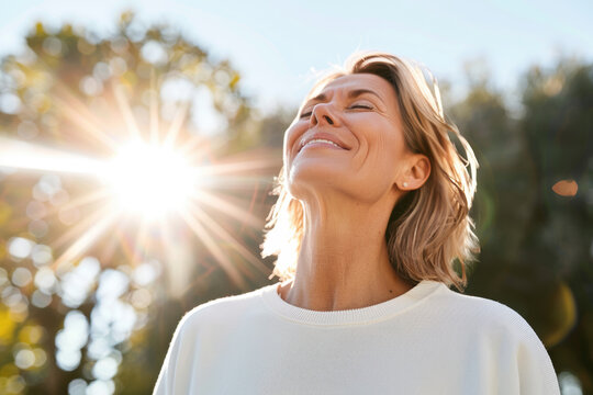 Portrait of happy mature woman enjoying wonderful sunny day in nature