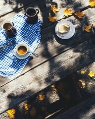 A wooden table topped with two cups of coffee and a plate of food