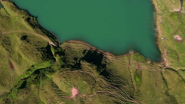 4K Aerial Drone video of the most beautiful mountain lake Schrecksee in Bavarian Alps with the cows feeding on lush green grass on a sunny day with blue skies and rocky hill tops surrounding
