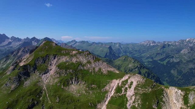 4K Aerial Drone video of the most beautiful mountain lake Schrecksee in Bavarian Alps with the cows feeding on lush green grass on a sunny day with blue skies and rocky hill tops surrounding