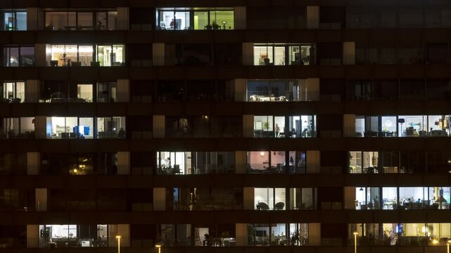 Nighttime time-lapse of a close-up view of building windows. Ideal for projects focused on urban life, cityscapes, and modern living.