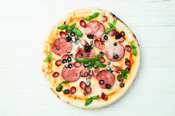 Pizza with mozzarella cheese , salami sausages , olives , and basil