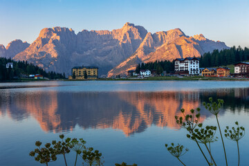 Lake Misurina in the morning sunrise time with alpenglow on mountain peaks and water plants at the...