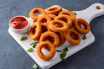 Fried onion rings with mozzarella or plain. Delicious onion rings on black background