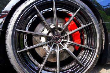Alloy wheel with calipers and racing brakes of the sport car. Racing brake disc and low profile tyres. Race car test driving. Lower-profile tires of drag and drift cars. High-performance sports cars. © MaxSafaniuk