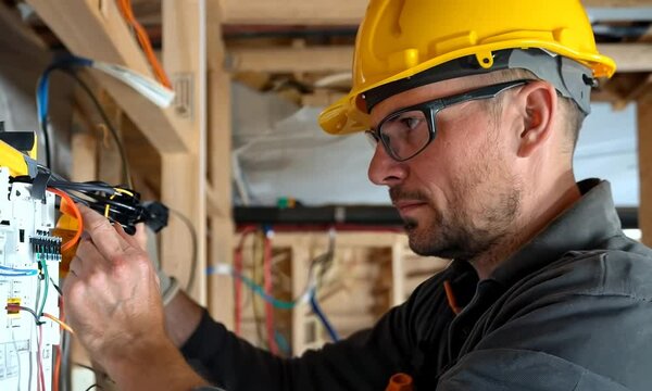 An electrician installing wiring and fixtures in a residential home. Video