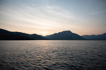 Stunning sunset over mountains and sea on wild natural islands in the northern region of the world, a journey to the cold and fiery sunsets of nature