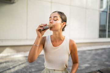 young business woman sit outdoor hold flask and drink alcohol