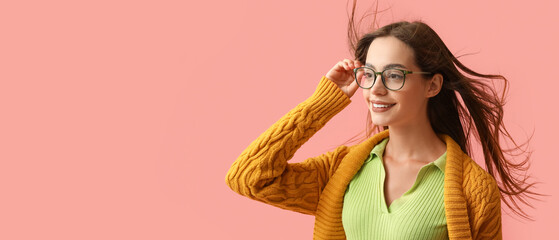 Beautiful young woman in stylish autumn clothes on pink background with space for text