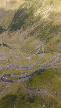 Top cinematic aerial view to the Transfagarasan famous curvy road in Romania. Aerial view of Transfăgărașa road in Fagarash Mountain. Romanian wild nature and landscape. 
