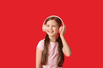 Little girl in headphones on red background