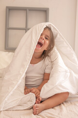 the little girl playing and tickling on the bed and having fun