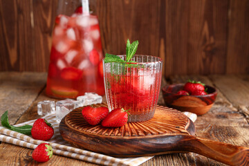 Glass of infused water with strawberry on wooden background