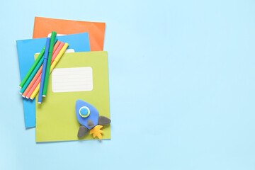 Rocket made of plasticine with stationery on blue background