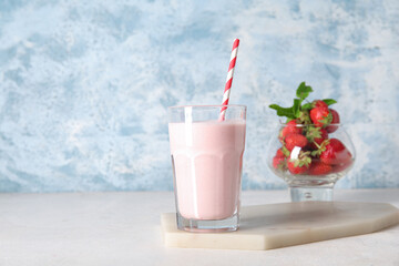 Glass of tasty strawberry smoothie on table