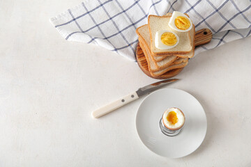 Holder with boiled chicken egg and bread on white background