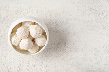Delicious white chocolate candies with coconut topping on light table