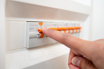 Close up of man hand and electrician with electricity fuse box, check power supply with maintenance...