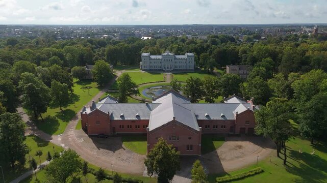 Aerial View of Plunge City in Lithuania. Plunge Manor Oginski Residential Manor and Park With Fountain and Samogitian Art Museum. Panorama of the City and St. John the Baptist Church