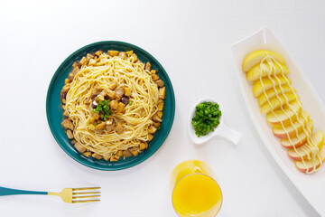 Mushroom and diced meat noodles, fruit salad, chopped green onion, top view