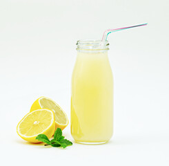 Close-up of a glass of lemonade with mint and drinking straw, white background