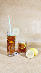 Two glasses of lemon cocktail, ice cubes, refreshing and cold, marble background