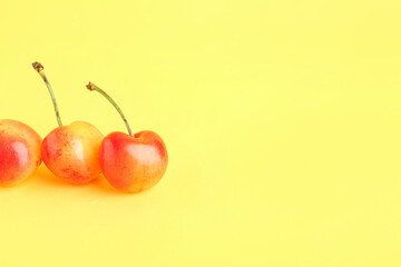 Sweet yellow cherries on color background