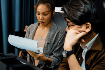 Serious face of working sales manager discussing on report data analysis paperwork with coworker at...