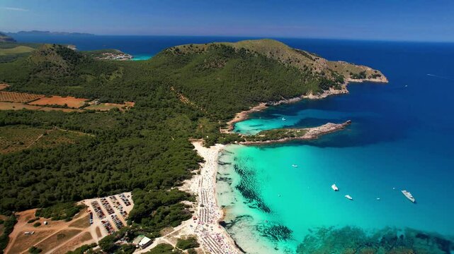 Pristine turquoise waters of Cala Agulla beach from above. Aerial 4K drone view of scenic Mediterranean coastline and nature reserve in Mallorca, Spain.