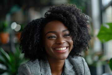 Smiling businesswoman in an office, showcasing confidence and ambition as an HR manager and entrepreneur with curly hair