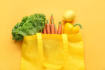 Eco bag with different fresh vegetables on beige background