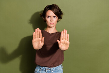 Portrait of serious gloomy woman with short hair wear oversize t-shirt stretching palms to stop you...