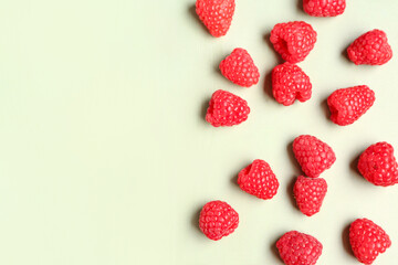 Many fresh raspberries on light green background