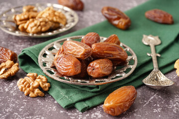 Bowl with dried dates on grey background