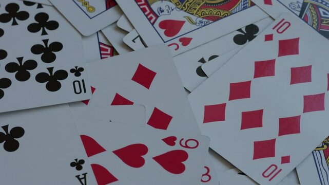 Pile of playing cards background rotating macro video. Shuffled suits and numbers. Gambling and casino concept.