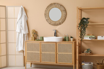 Modern sink with bath supplies on countertop near brown wall in bathroom