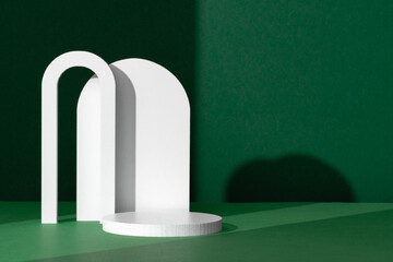 Modern White Architectural Shapes Against A Deep Green Background Displayed On A Simple Table...