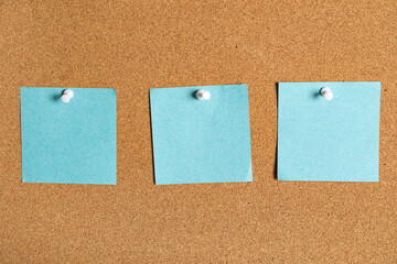 Blank sticky notes on cork board as background
