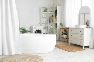 Bathtub with curtain and chest of drawers with sink in interior of bathroom