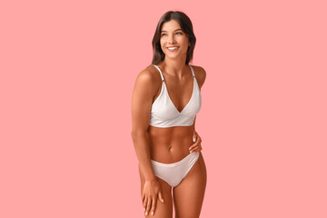 Obraz premium Beautiful young happy body positive woman in underwear on pink background