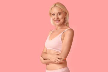 Beautiful mature happy body positive woman in underwear on pink background