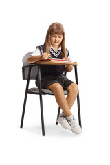 Schoolgirl sitting in a chair and writing