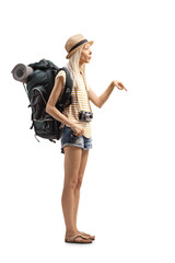 Full length shot of a young female tourist with a backpack pointing