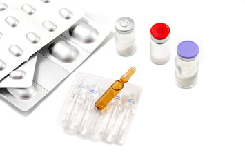 Glass medical ampoule isolated on white background. Glass medical ampoules of different shapes on a white background. Tablets in gray aluminum packaging.